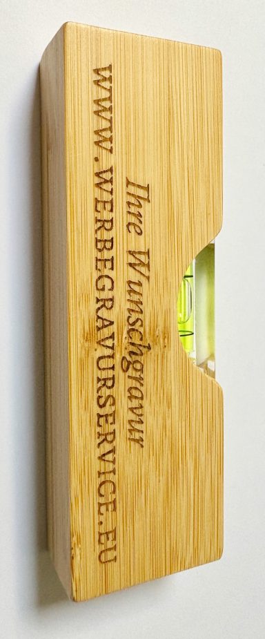 Holzkasten mit Gravur und Sichtfenster zur Anzeige eines grünen Objekts.